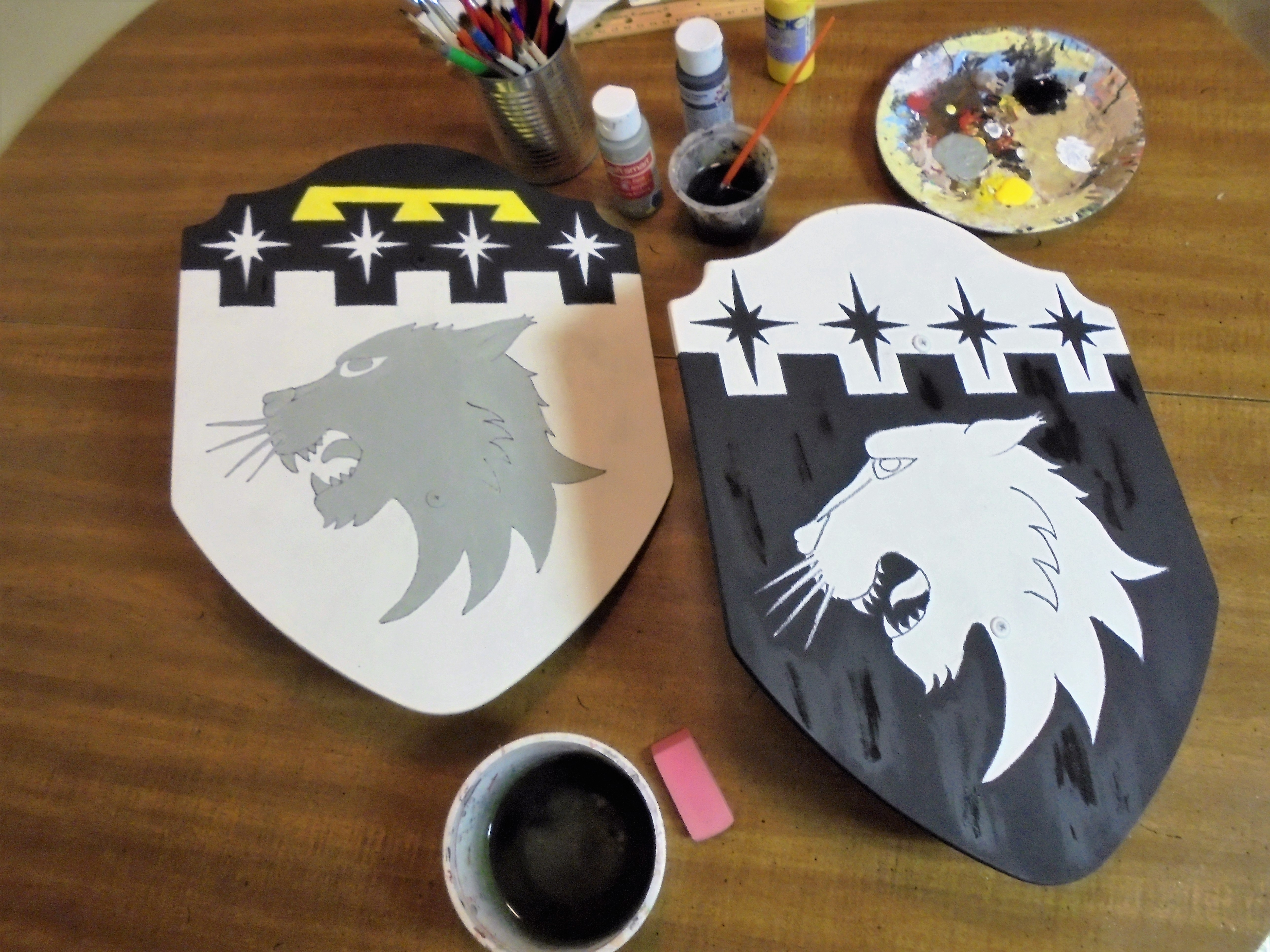 Work in progress... toy shields I'm painting for my brother's kids. They bear his coat of arms differenced (eldest with a a label and second son with reverse tinctures). His kids are 7 and 4 years old so just old enough to enjoy playing with wooden shields I think. The grey cougar head is just a base-coat, it will end up black when finished. Need to do detail painting now, then varnish, sand, varnish, sand some more. :D